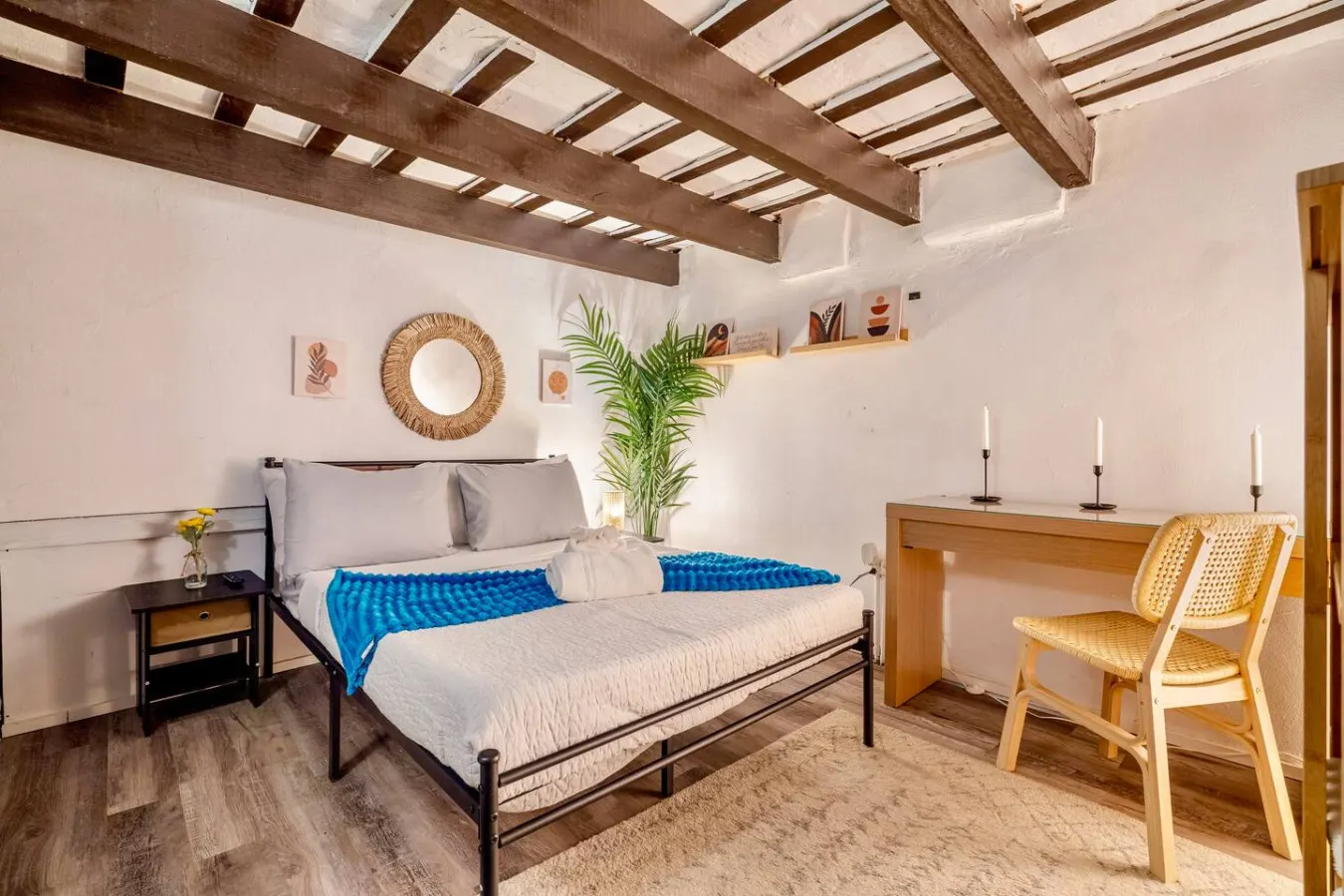 Bedroom with a blue bedspread and a potted plant on the nightstand — La Cueva Loft Rustic Colonial Romance, Old San Juan