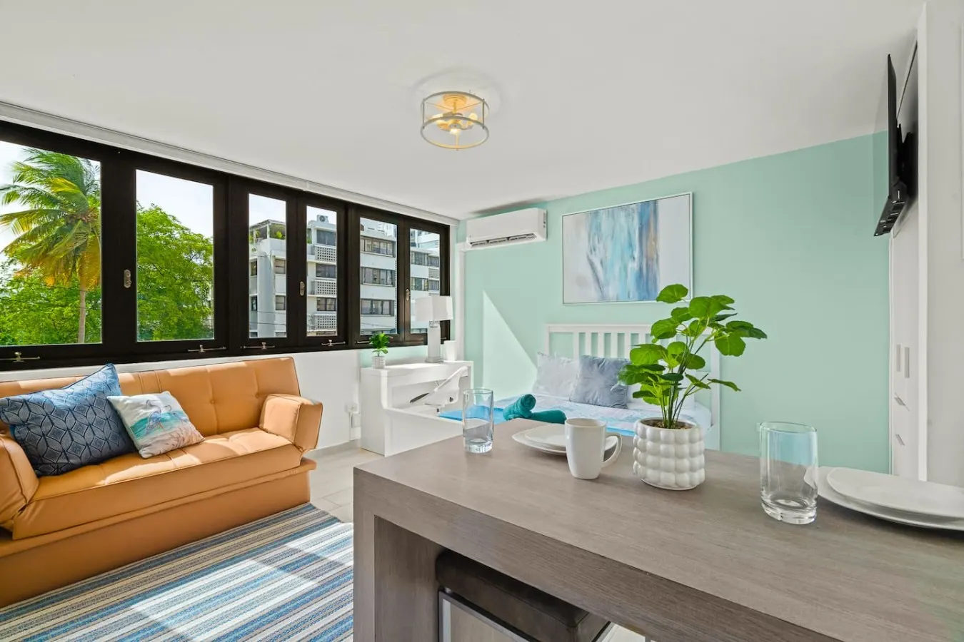 Living room with a couch, a table, and a potted plant — Casa Celeste | Sunlit Tropical Stay in Condado, Santurce