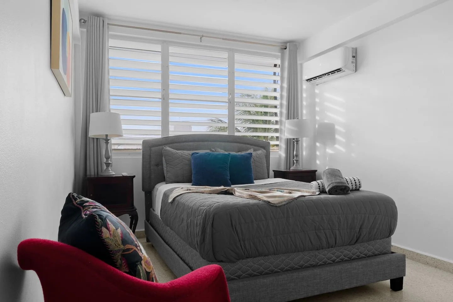 Bedroom with a large bed and a red chair — Maré 2BR | Near Ocean Park Beach + Laundry, Santurce
