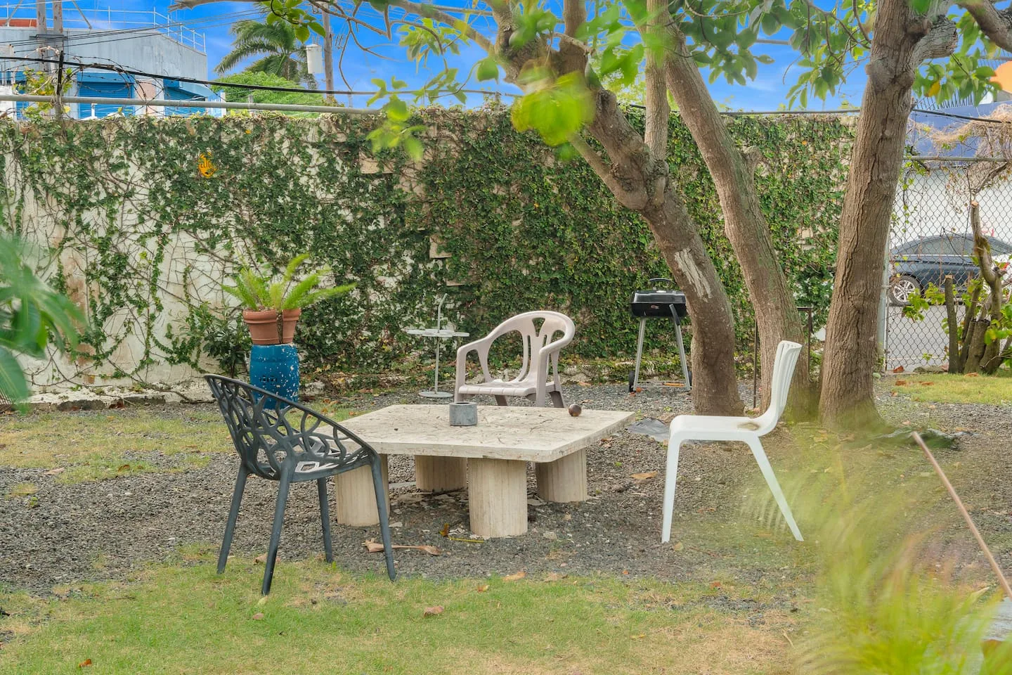 Patio table with chairs and a grill in the backyard — Maré 2BR | Near Ocean Park Beach + Laundry, Santurce