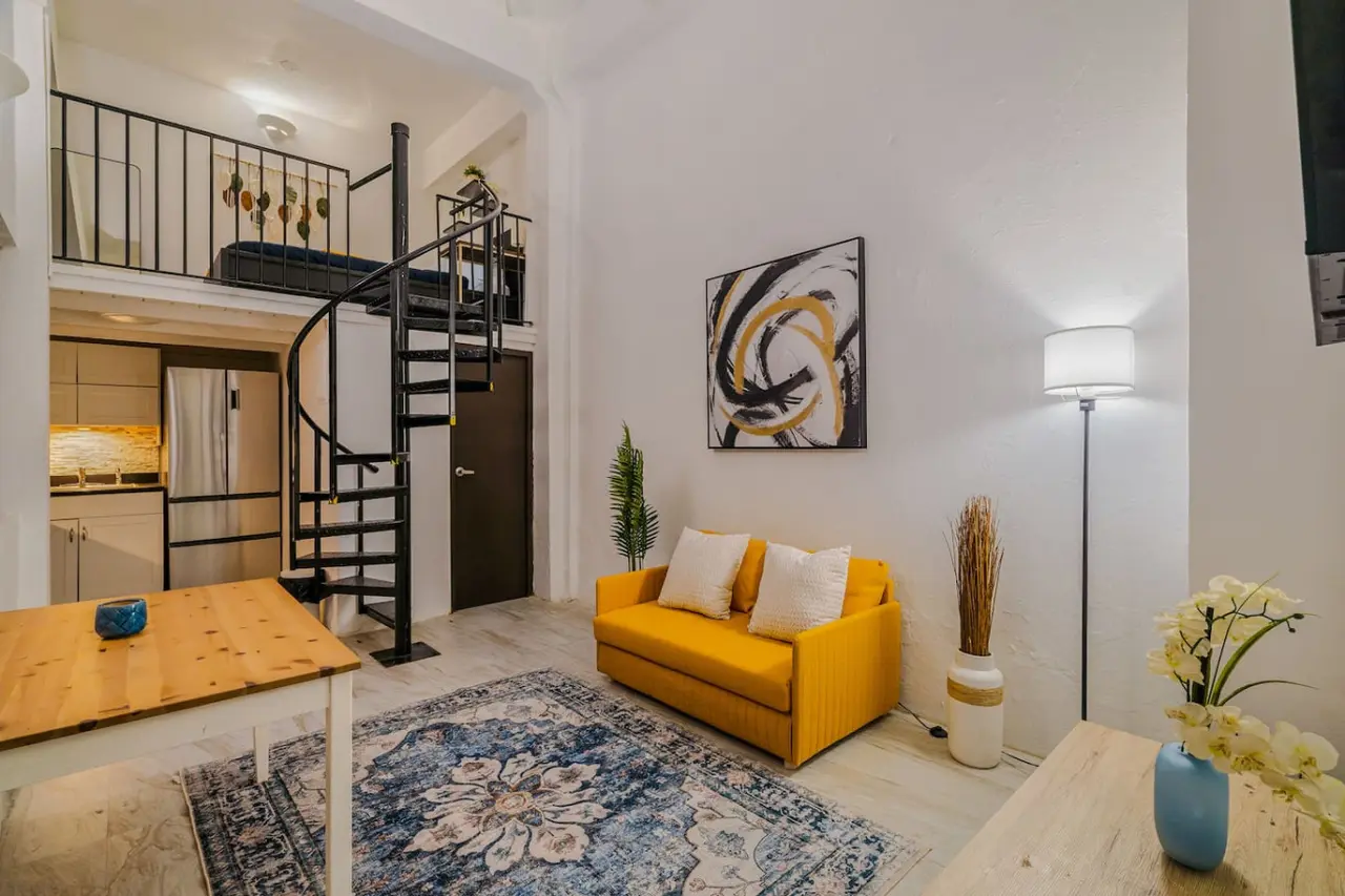 Living room with a yellow couch and a potted plant — Loft La Luz - Old San Juan