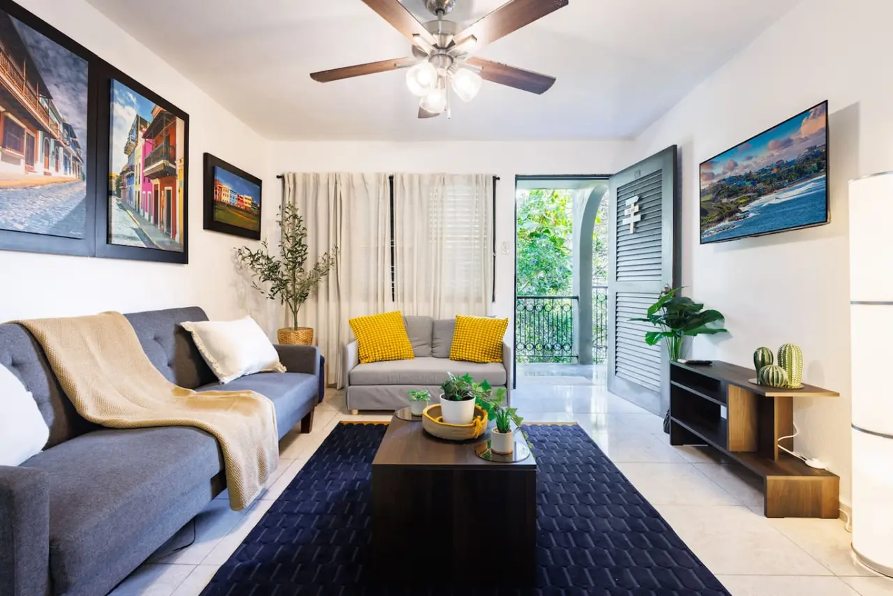 Living room with a couch, coffee table, and potted plants — Ocean Sol Historic Old San Juan