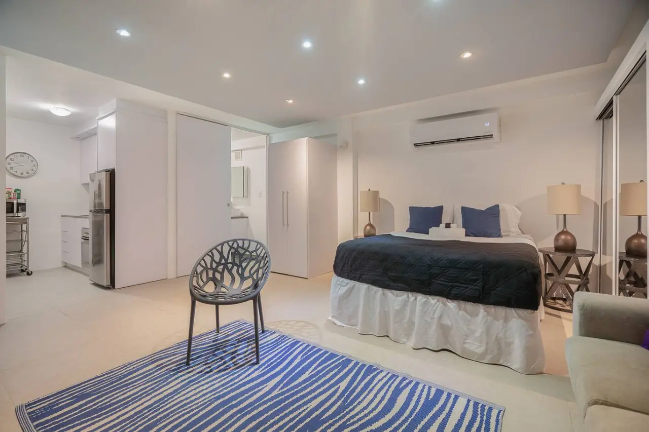Sleeping area with a bed and two bedside lamps — Punta Las Marias Studio - Short Walk to the Beach, Santurce