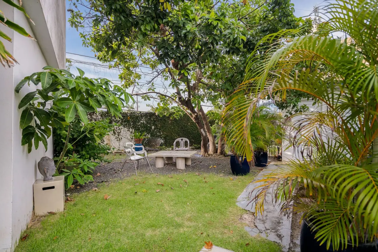 Building's garden with a stone table under a tree — Punta Las Marias Studio - Short Walk to the Beach, Santurce