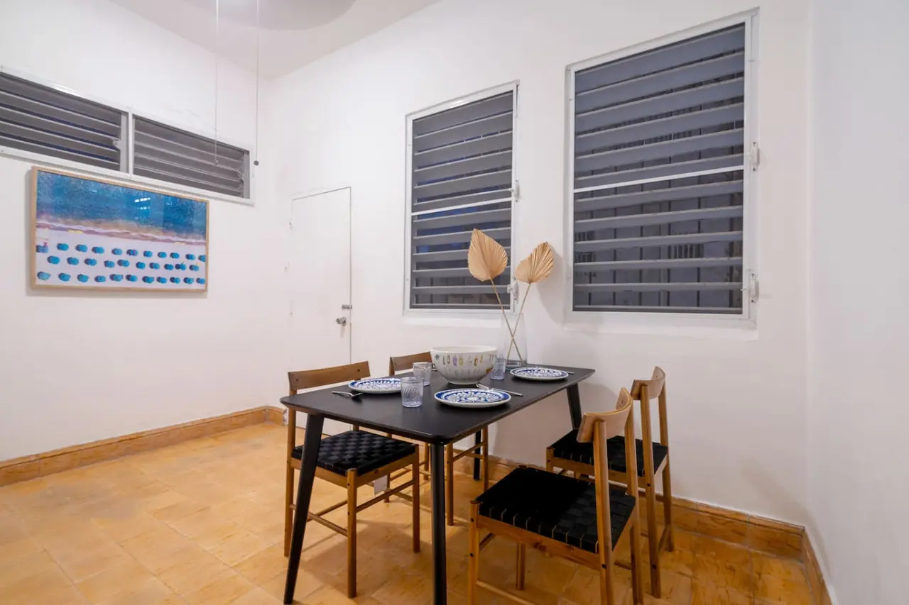 Dining area with a black table and wooden chairs — Luz Collection No.3 – Casa Horizonte | 3BR Loft, Santurce