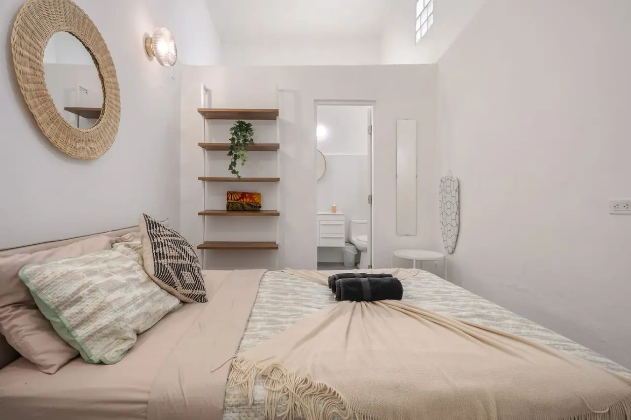 Bedroom with a bed, a bookshelf, and a mirror — Downtown San Juan Gateway Dream, Santurce