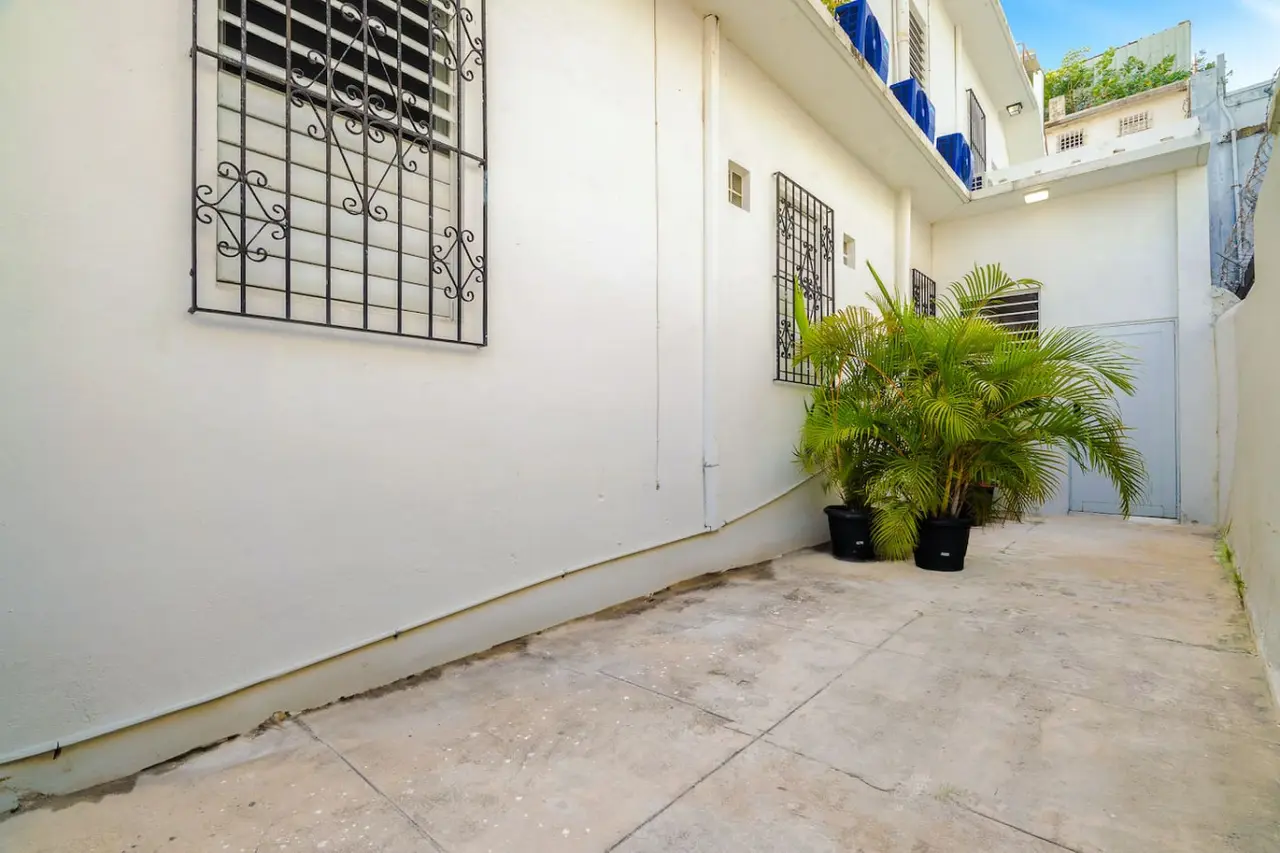 Patio with potted palms along white walls — Downtown San Juan Gateway Dream, Santurce