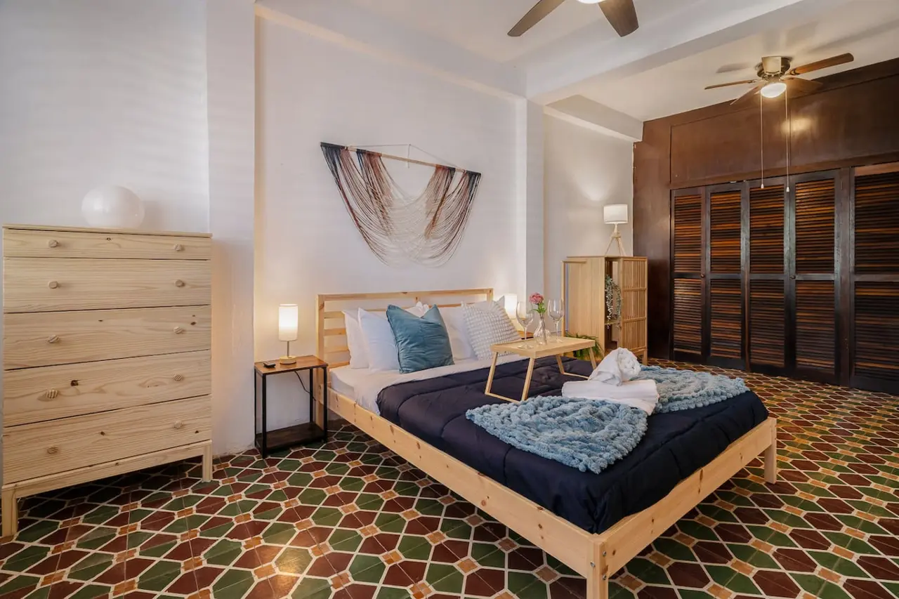 Bedroom with a blue bedspread and a white pillow — Tapia Mosaic Beachwalk - San Juan, Santurce