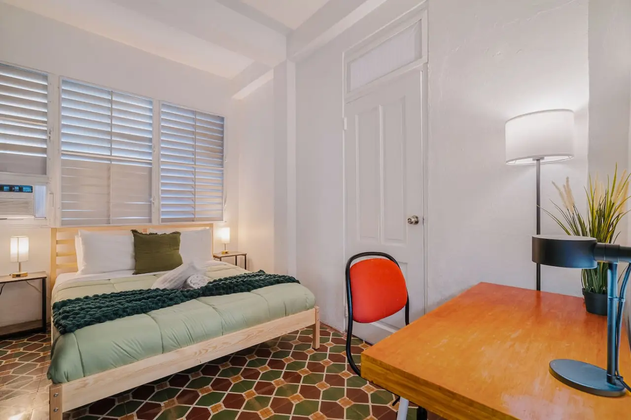 Bedroom with a bed, a chair, and a table — Tapia Mosaic Beachwalk - San Juan, Santurce