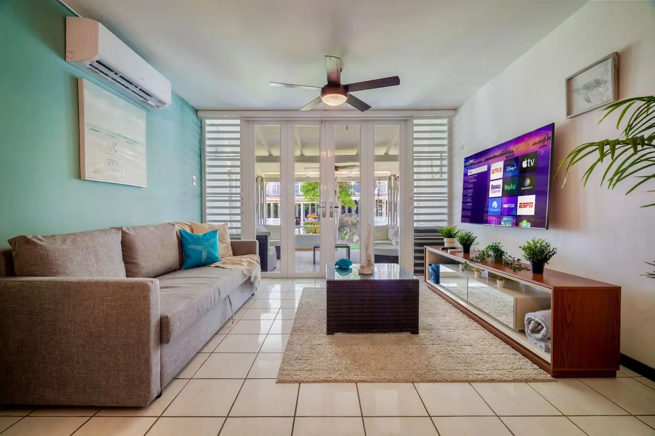 Living room with a couch, a coffee table, and a large flat screen TV — Beach Villa Dorado Del Mar