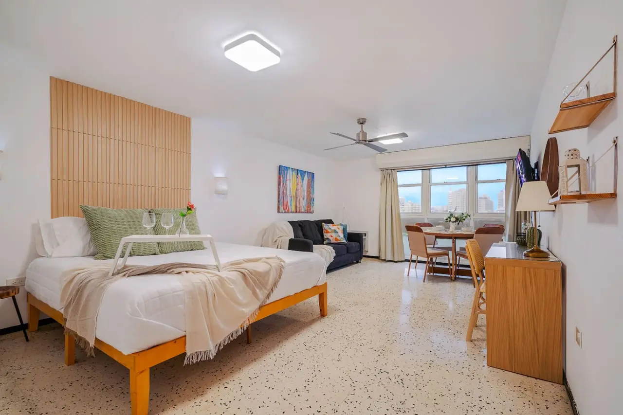 Bedroom with a bed, nightstand, and a painting on the wall — Condado Penthouse