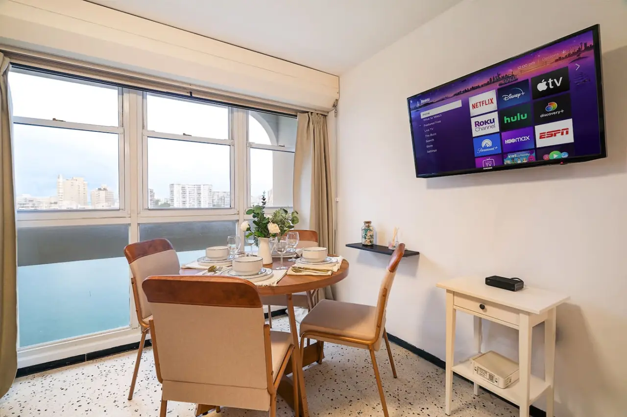 Dining area by windows overlooking the lagoon — Condado Penthouse