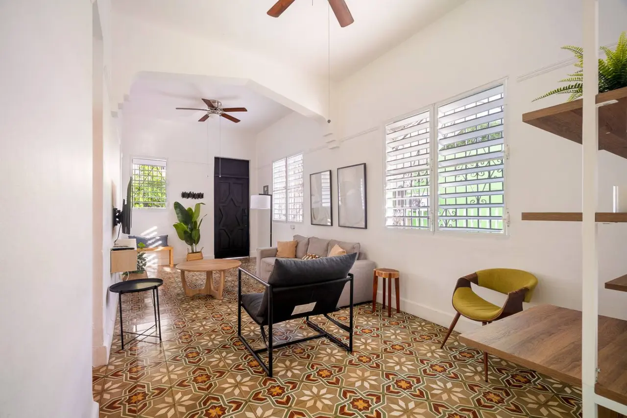 Living room with a grey sofa, armchair and patterned tiles — Luz Collection No.2 – Casa Brisa | 3BR Retreat, Santurce