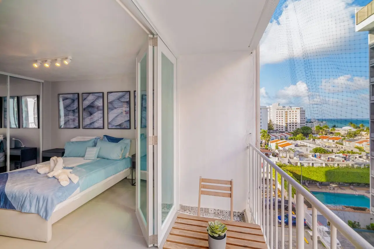 Bedroom with a bed, a chair, and a potted plant — OceanSide - Pool Balcony, Isla Verde