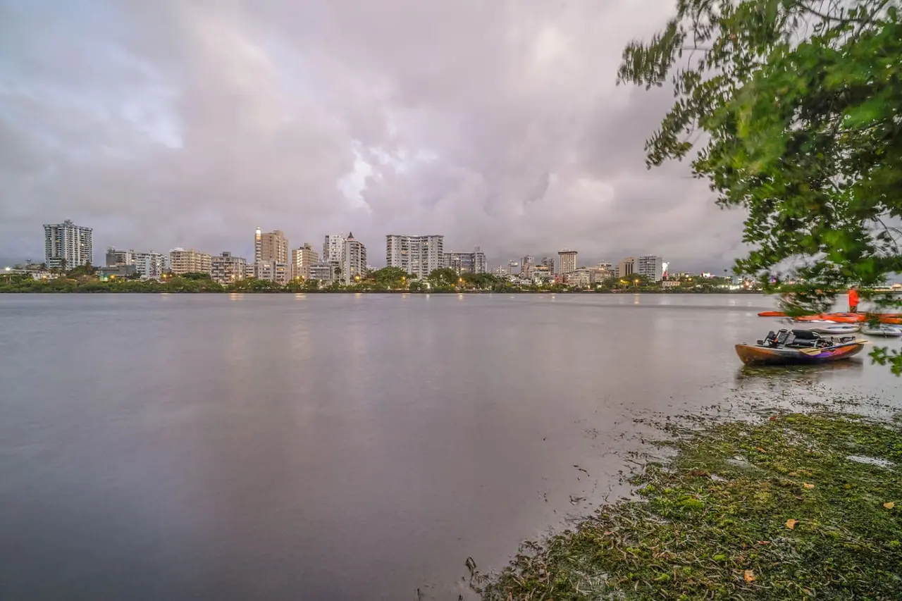 City skyline across the lagoon at dusk — Condado Penthouse