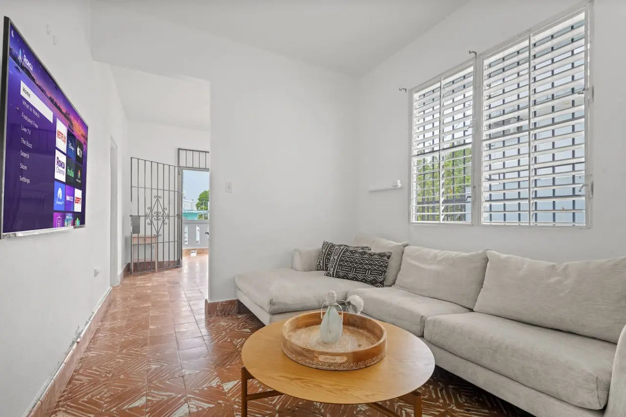 Living room with a sectional sofa and a wall-mounted TV — Sunkiss in Puerto Rico San Juan 3 Bedroom, Santurce