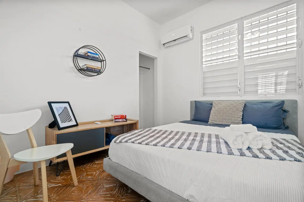 Bedroom with a queen bed, a desk and a round wall shelf — Sunkiss in Puerto Rico San Juan 3 Bedroom, Santurce