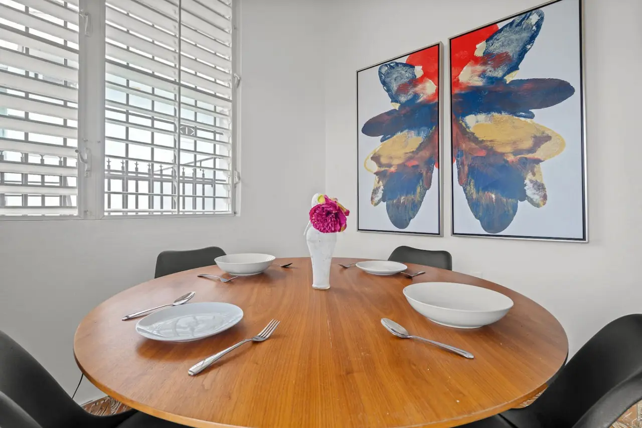 Dining table with a vase of flowers on it — Sunkiss in Puerto Rico San Juan 3 Bedroom, Santurce