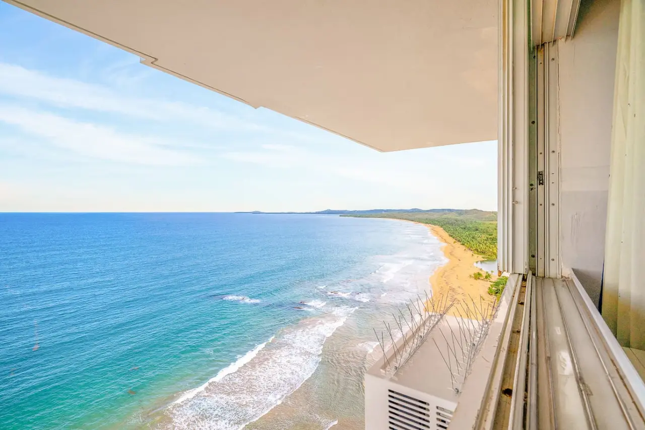 Balcony view of the coastline and beach — Captain’s Beachfront Luquillo Beach House