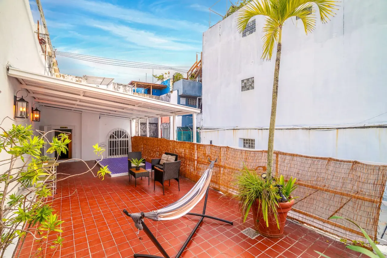 Rooftop terrace with a hammock, palm and rattan chairs — Villa Mansion - Fountain & Rooftop - Old San Juan