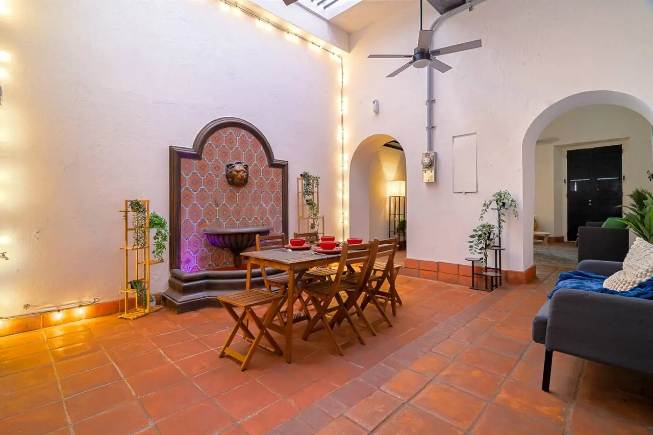 Dining room with a tiled wall fountain and string lights — Villa Mansion - Fountain & Rooftop - Old San Juan