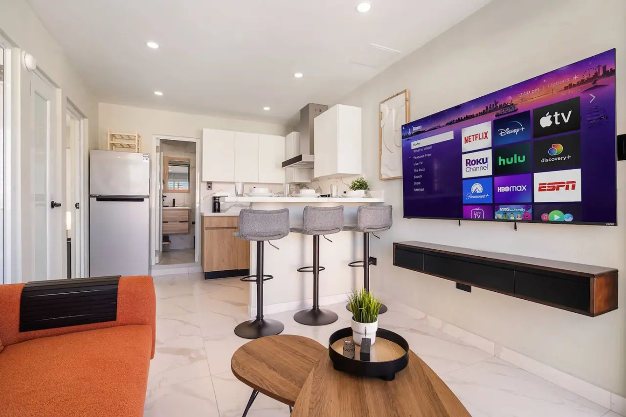 Living room with a flat screen TV on the wall — SunJoy Modern 2BR Apartment Isla Verde, Carolina