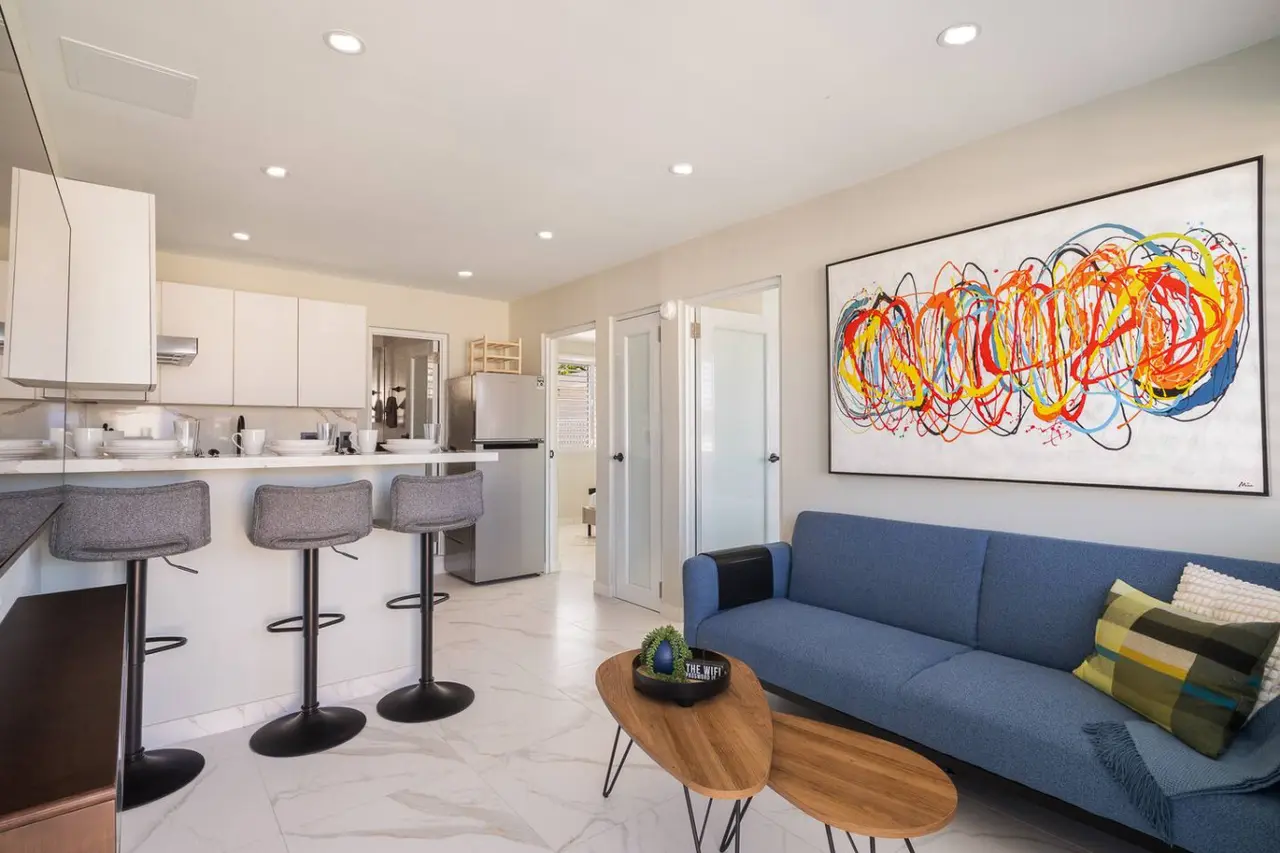 Living room with a blue sofa and an open kitchen — MoonJoy Chic 2BR Apartment Private Patio, Carolina