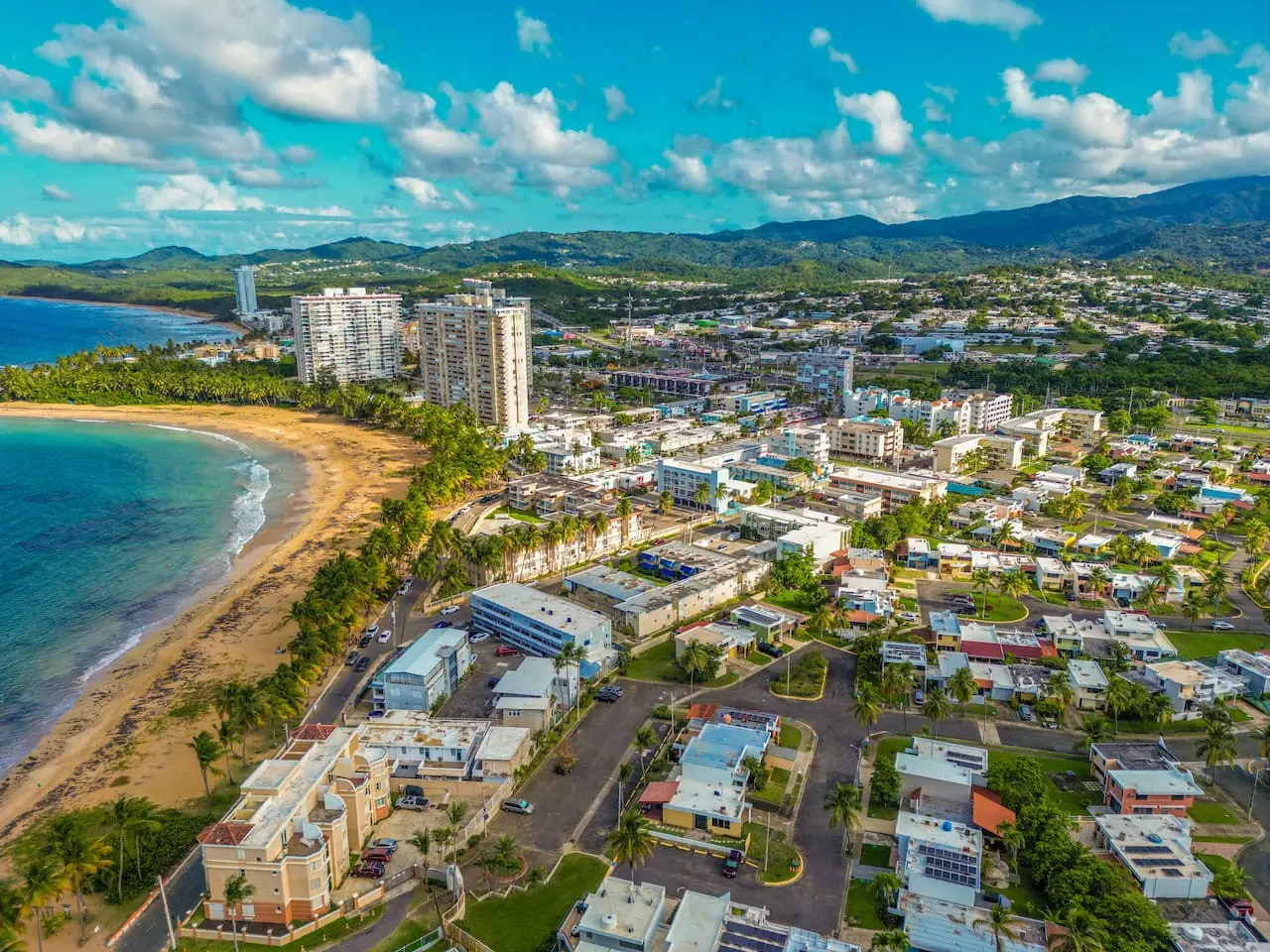 Aerial view of the town with green hills behind — Walking to the Beach 3 bedroom House Next to Ocean, Luquillo
