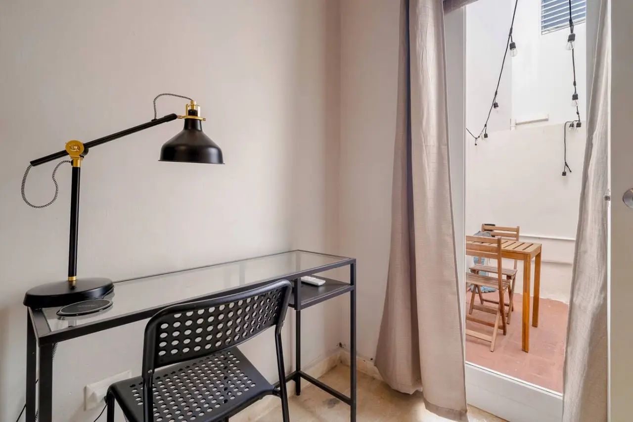 Bedroom desk with a lamp and an open door to the patio — Historical Old San Juan Spanish style private Patio