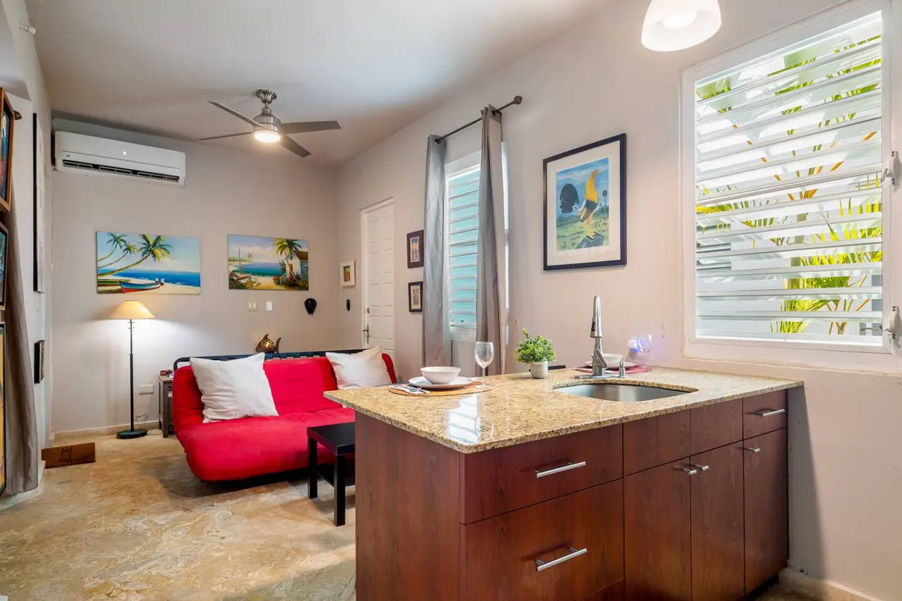 Kitchen with a sink and a red couch in the background — Historical Old San Juan Spanish style private Patio