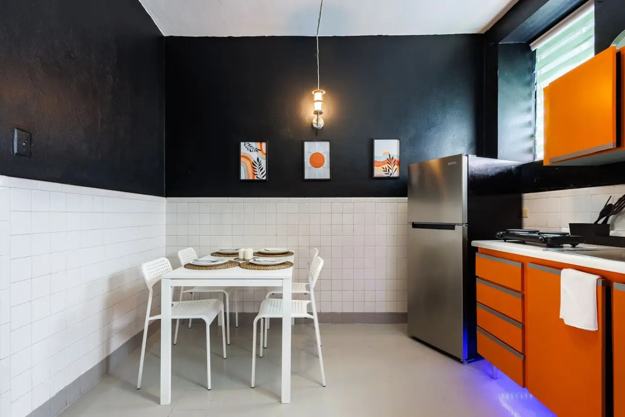 Dining room table with chairs and a refrigerator in the background — Spain Lagoon | San Juan | Private Patio, Santurce
