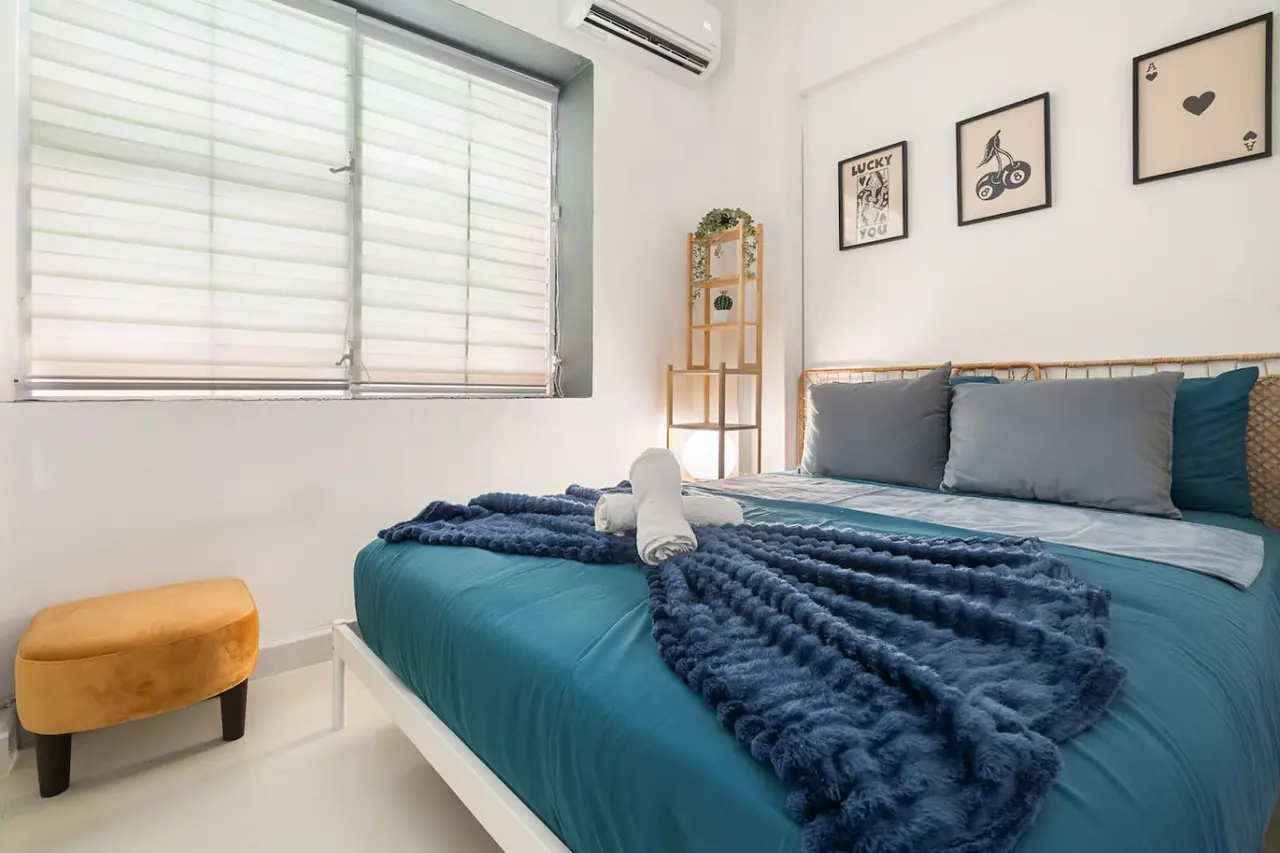 Bedroom with a queen bed, a navy throw and an ottoman — Puerto House - Private Patio, Santurce