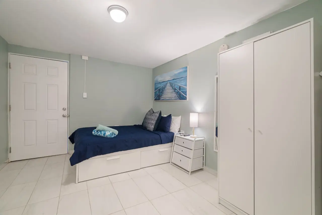 Bedroom with a bed, a nightstand and a tall wardrobe — Casa Juno I: Private Courtyard Studio, Santurce