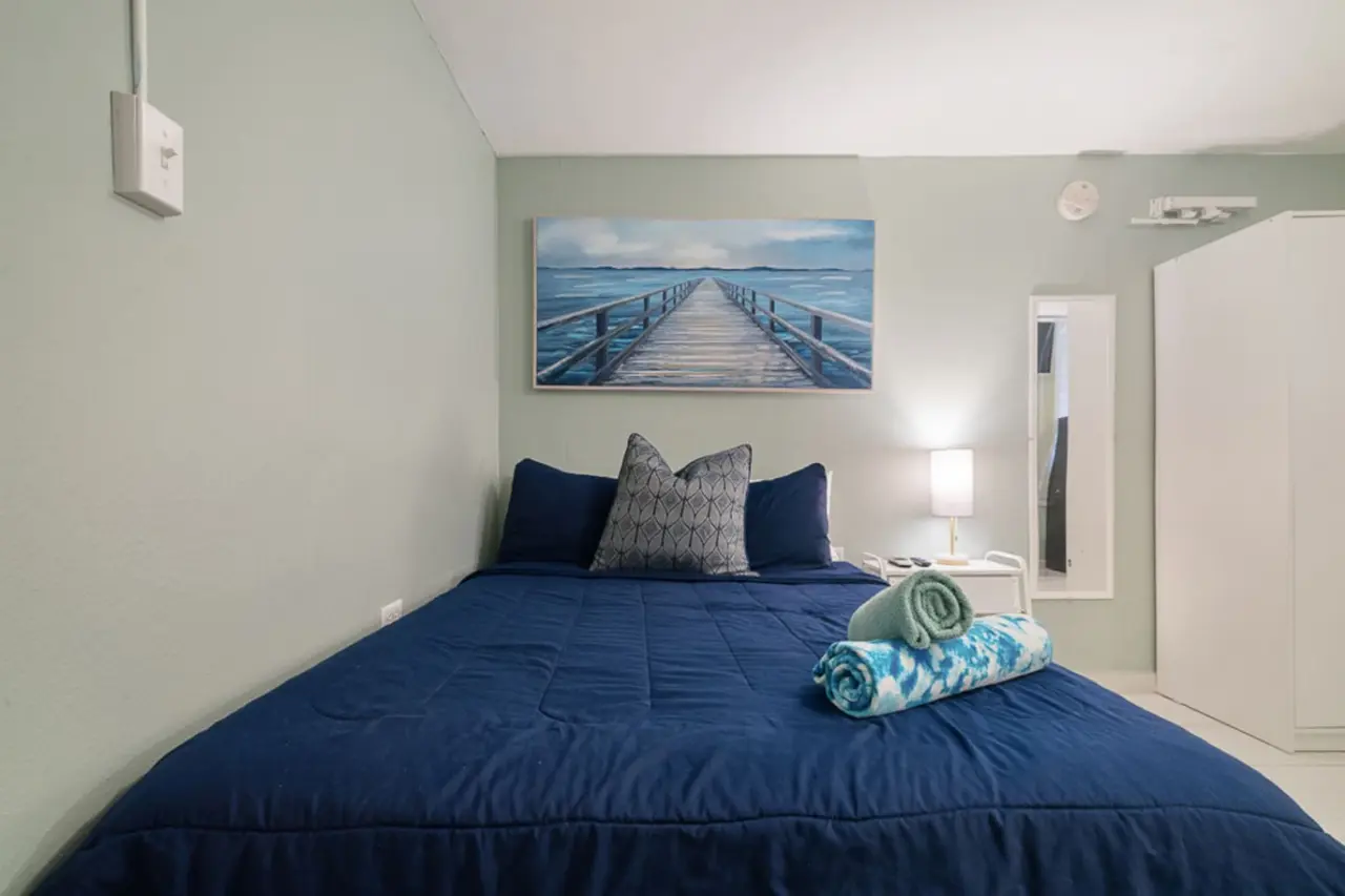 Bedroom with a queen bed, a lamp and a wardrobe — Casa Juno I: Private Courtyard Studio, Santurce
