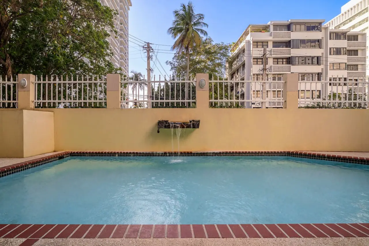 Pool with a fountain spout on its yellow wall — Luxe Beachside Oasis: Pool Parking & Generator, Santurce