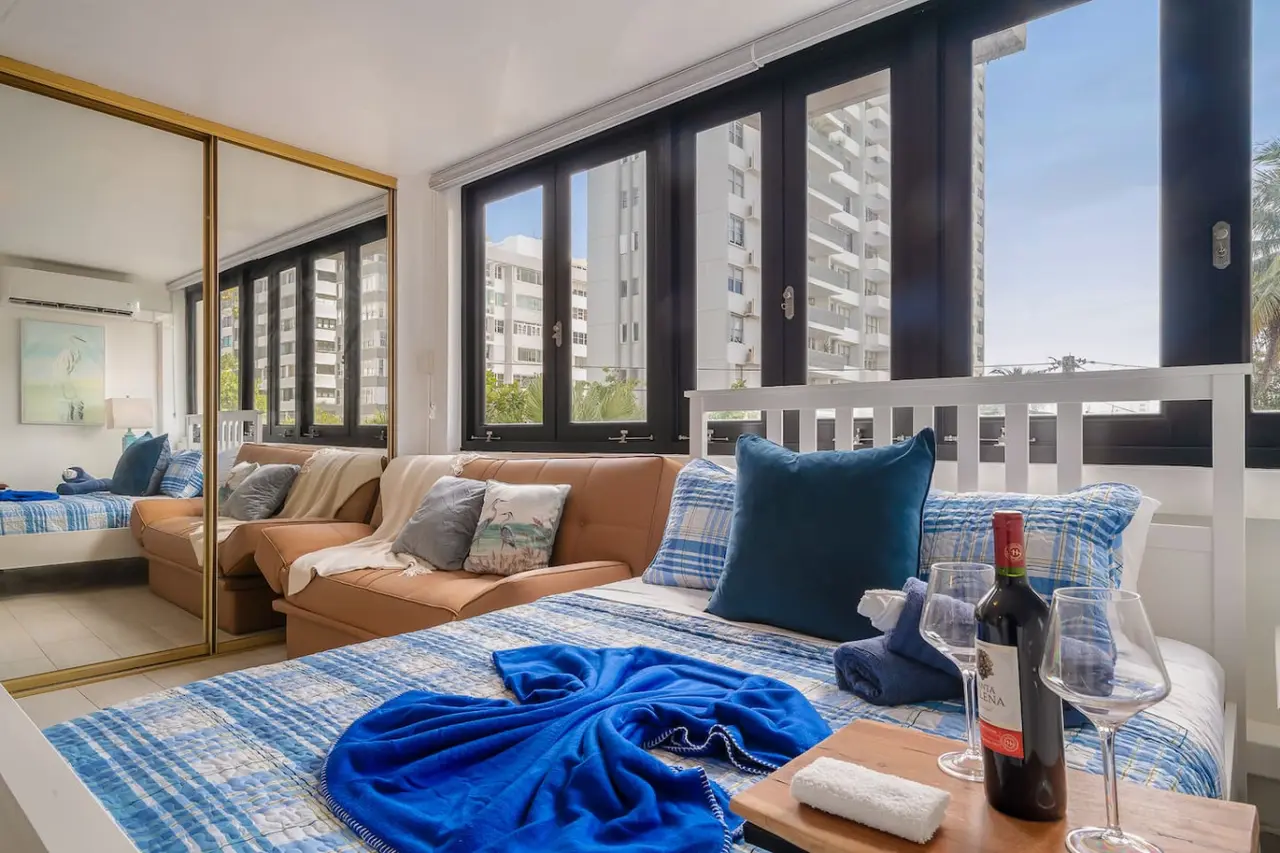 Bedroom area with a queen bed and a mirrored closet — Luxe Beachside Oasis: Pool Parking & Generator, Santurce