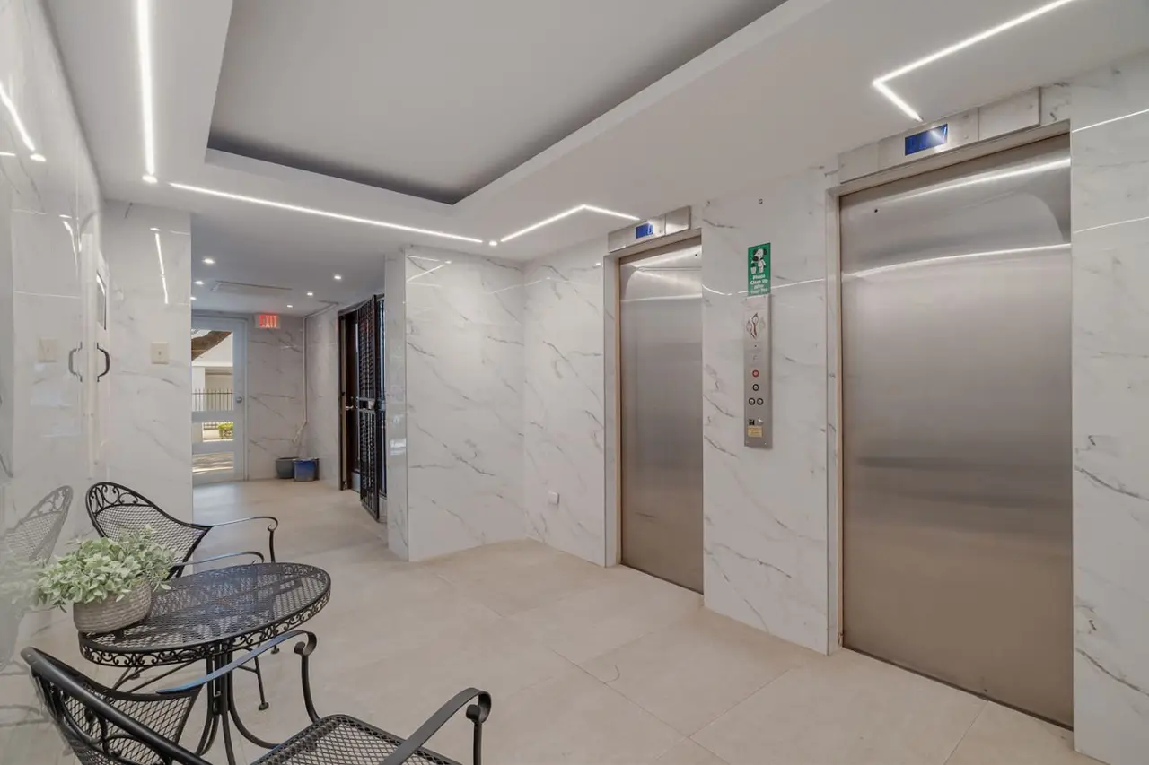 Marble lobby of the building, with two elevators — Luxe Beachside Oasis: Pool Parking & Generator, Santurce