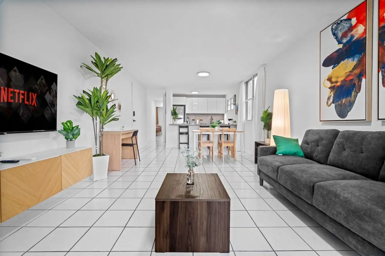 Living room with a couch, coffee table, and potted plants — High-Rise Condado Suite | Ocean Views & PR Skyline