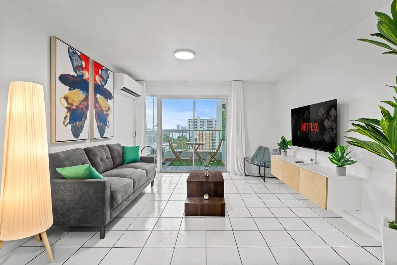 Living room with a couch, a chair, and a flat screen TV — High-Rise Condado Suite | Ocean Views & PR Skyline