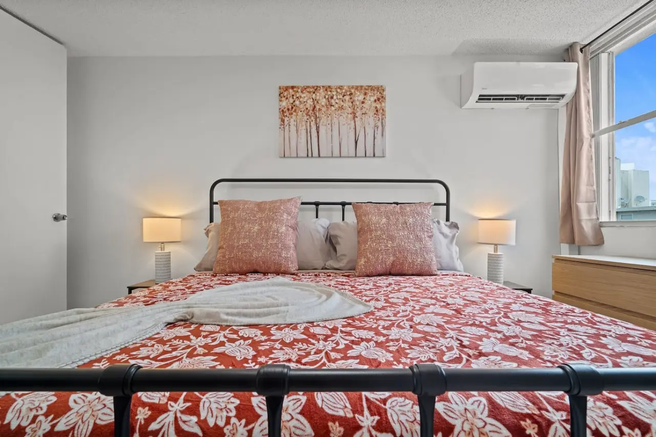 Bedroom with a bed and a painting on the wall — High-Rise Condado Suite | Ocean Views & PR Skyline