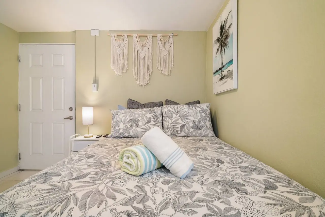 Bedroom with a bed, a lamp, and a towel on it — Romero Studio San Juan near beach, Santurce