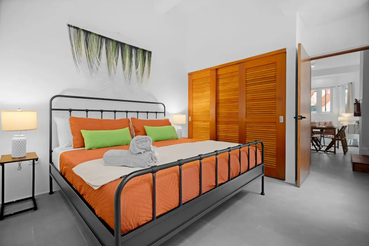Bedroom with a bed, nightstand, and a painting on the wall — Bellavista Galleria | Old San Juan