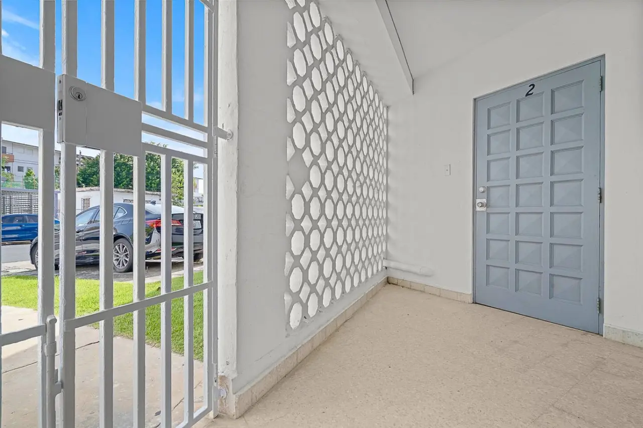 Gated entrance with a breeze-block wall and the front door — Ocean Park 2BR Backyard BBQ Walk to Beach, Santurce