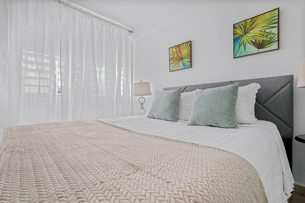 Bedroom with a white bedspread and two pillows — Ocean Park 2BR · Steps to Beach & Dining, Santurce