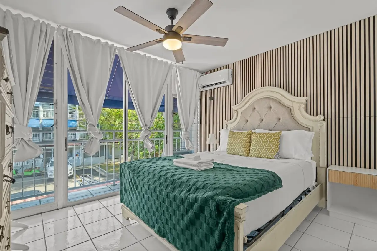 Bedroom with a large bed, green bedspread, and white pillows — Beachside Villa Dorado Pool Beach Access