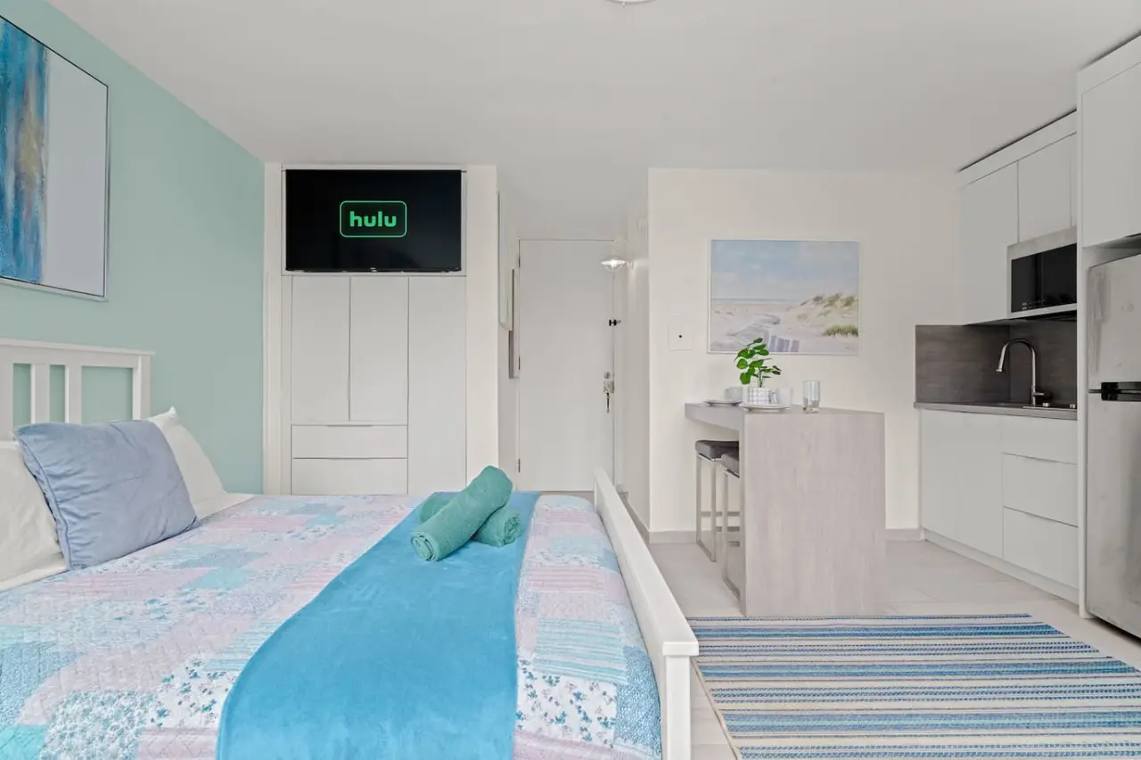 Bedroom with a blue bedspread and a television on the wall — Casa Celeste | Sunlit Tropical Stay in Condado, Santurce