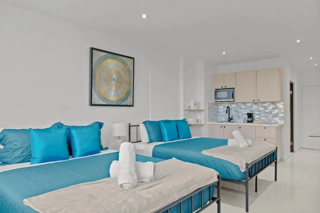 Two blue beds with blue pillows and blue sheets in a bedroom — T-Mobile District San Juan Next to Beach