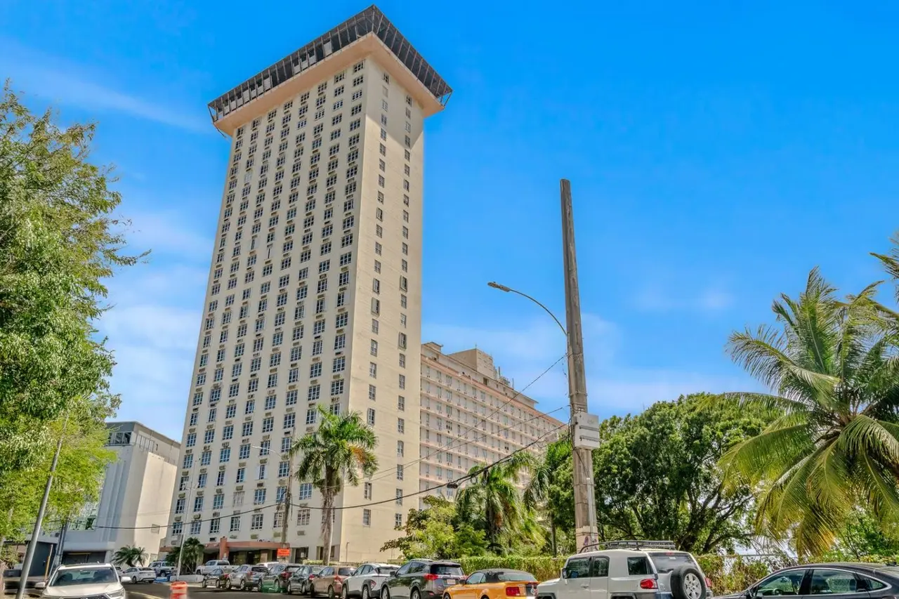 Tall white building, with palm trees and parked cars — Caribbean Sea View | T-Mobile District Free Parking, San Juan