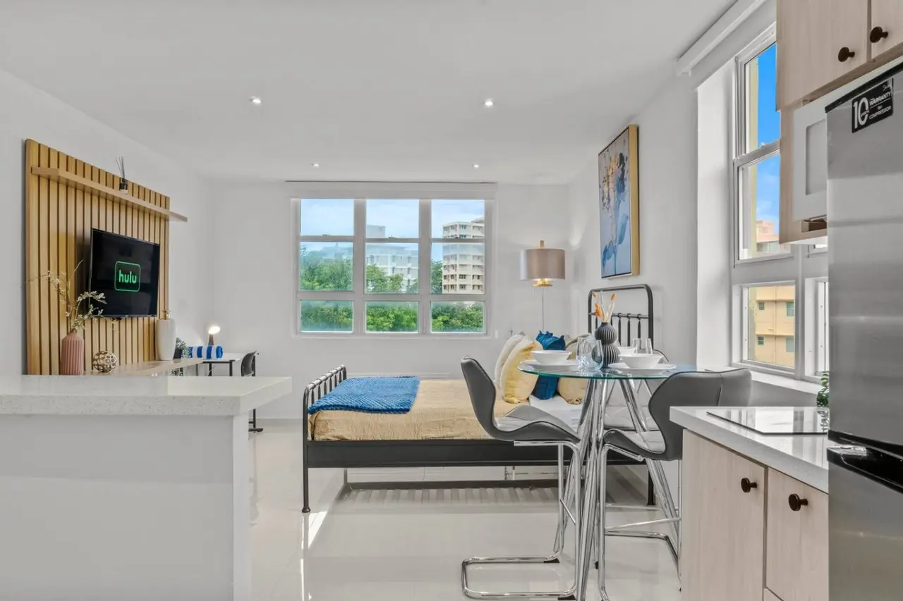 Bedroom with a bed and a window overlooking the city — Caribbean Sea View | T-Mobile District Free Parking, San Juan
