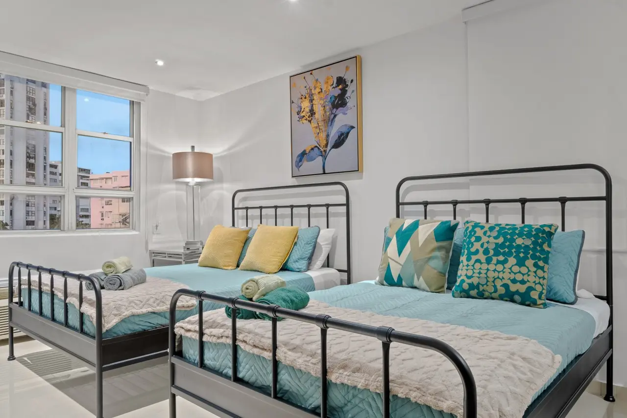 Bedroom with two beds and aqua bedding — Caribbean Sea View | T-Mobile District Free Parking, San Juan